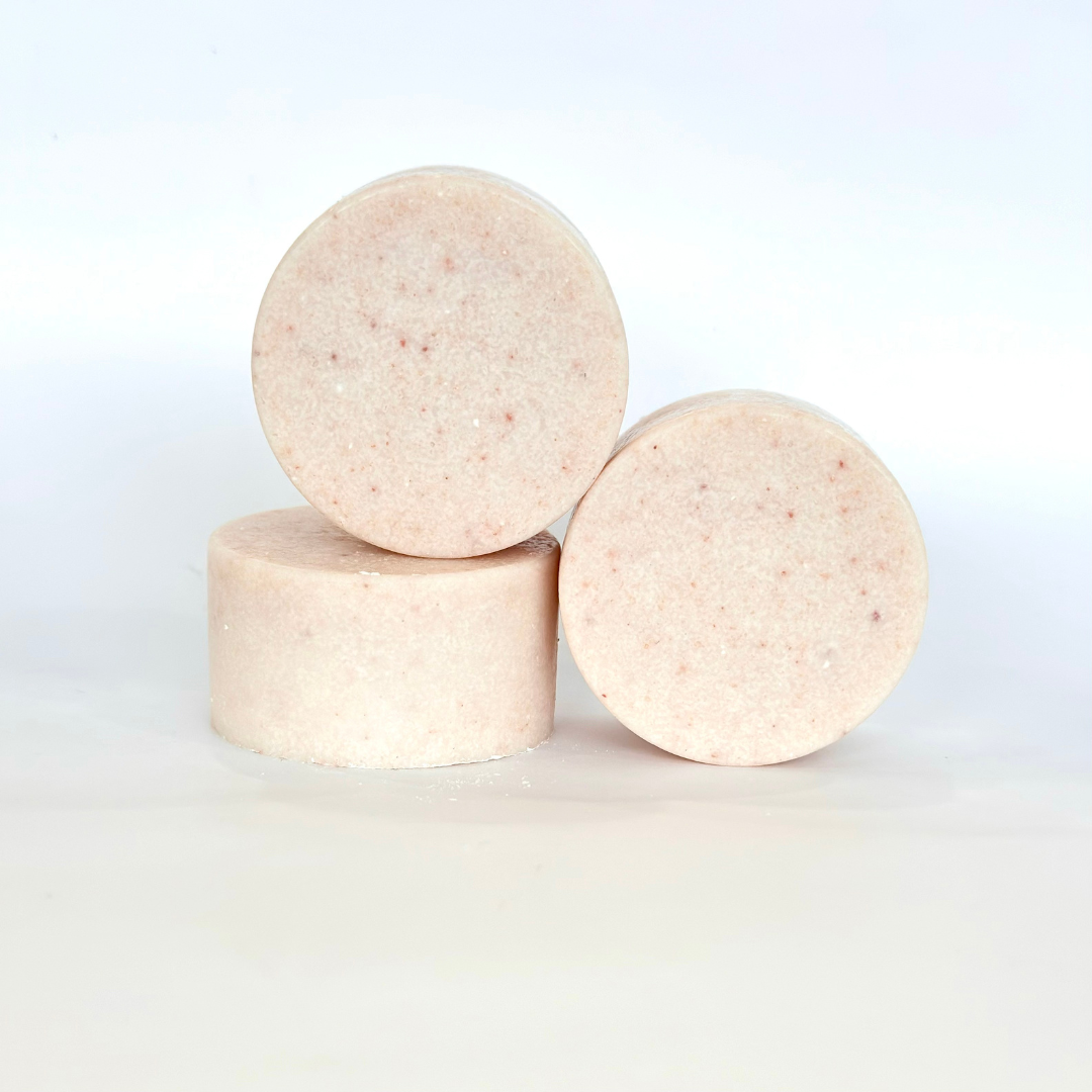 Front view of round Sweet Bouquet Himalayan Salt Scrub Bar on another bar lying down with another bar beside against a white background