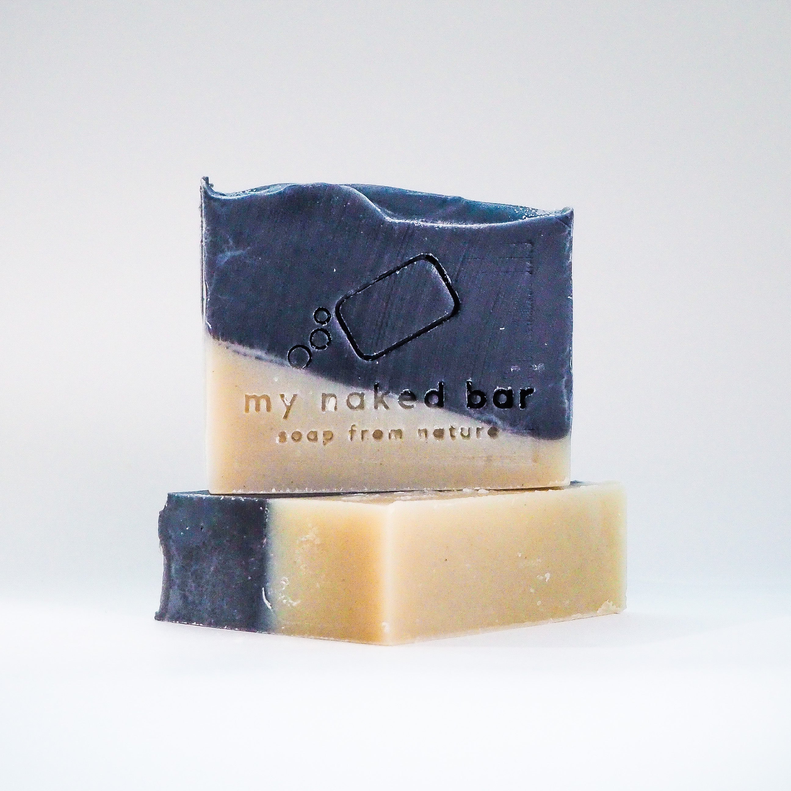 Front view of Black Mojo soap bar on top of another bar lying down