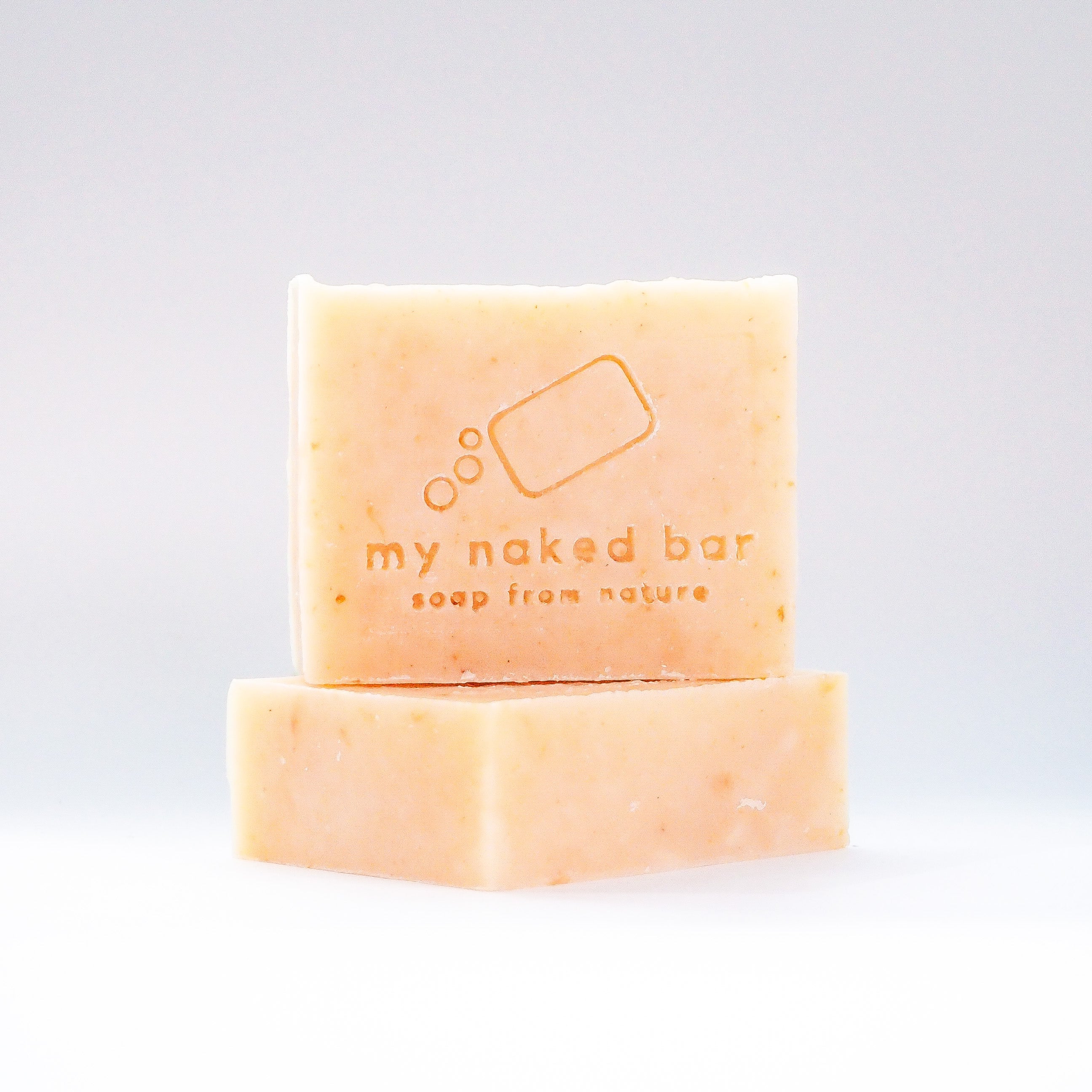 Front view of Ginger Bliss soap bar stacked on another bar lying down
