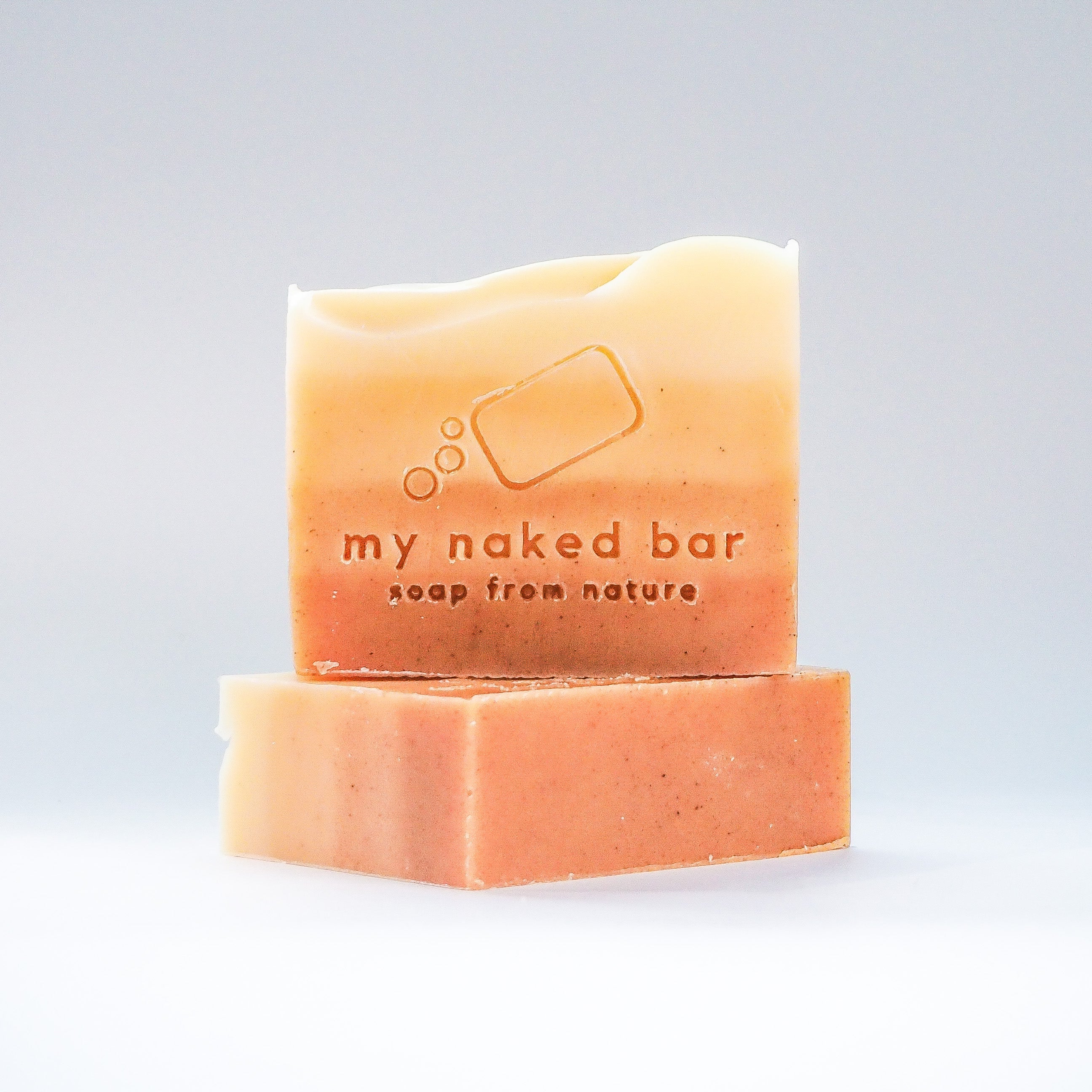 Turmeric Sunrise soap bar front view, stacked on another bar lying down.