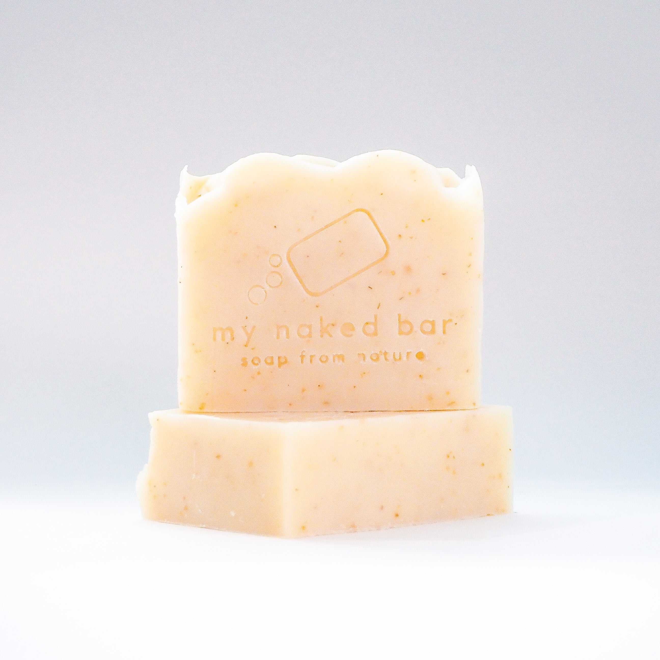 Front view of Unscented Oatmeal soap bar stacked on top of another bar lying down