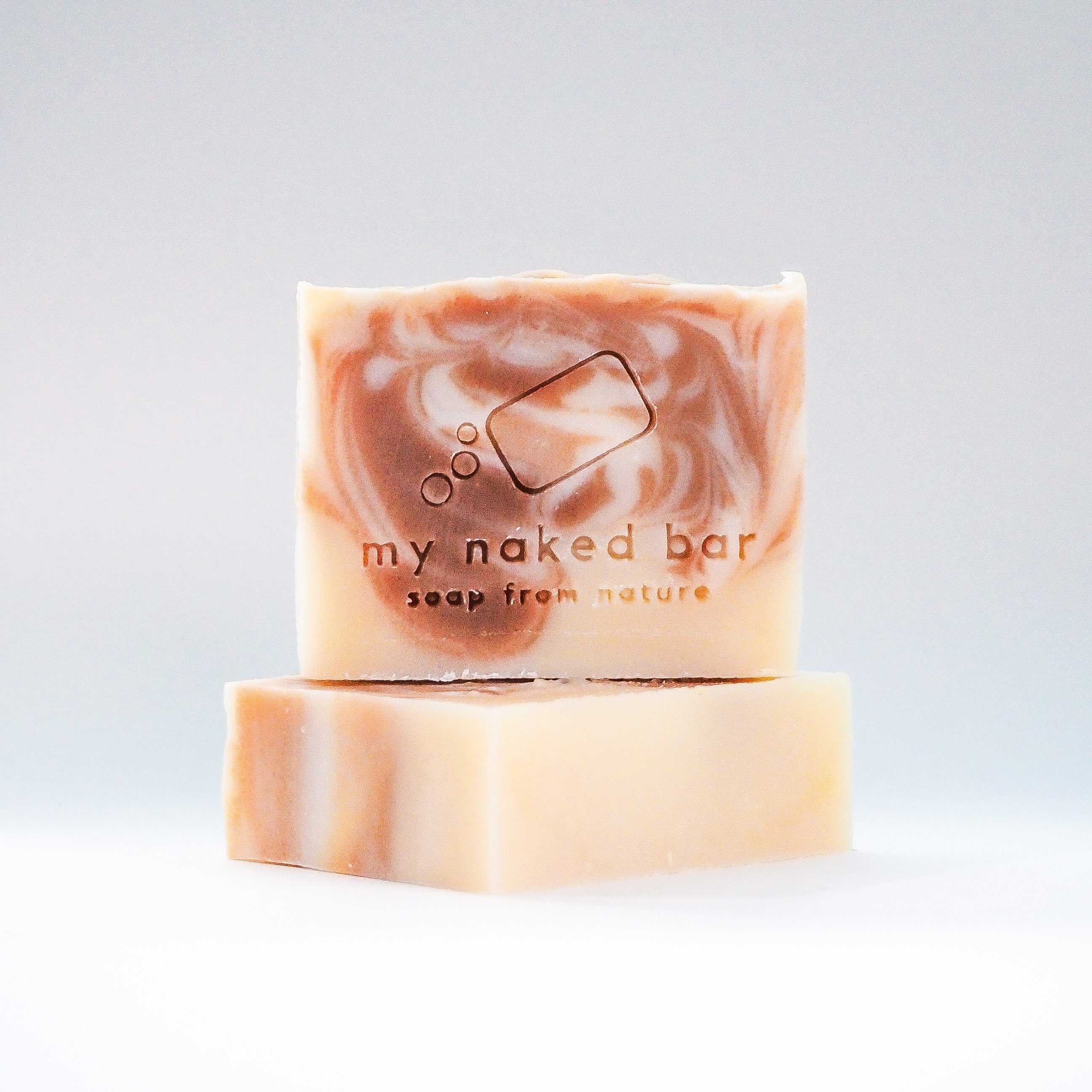 Front view of Vanilla Cocoa Swirl soap bar stacked on top of another bar lying down